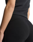 Primo piano del tessuto Soft Lux del pantalone Adidas donna, mostrando la texture morbida e la qualità del materiale nero