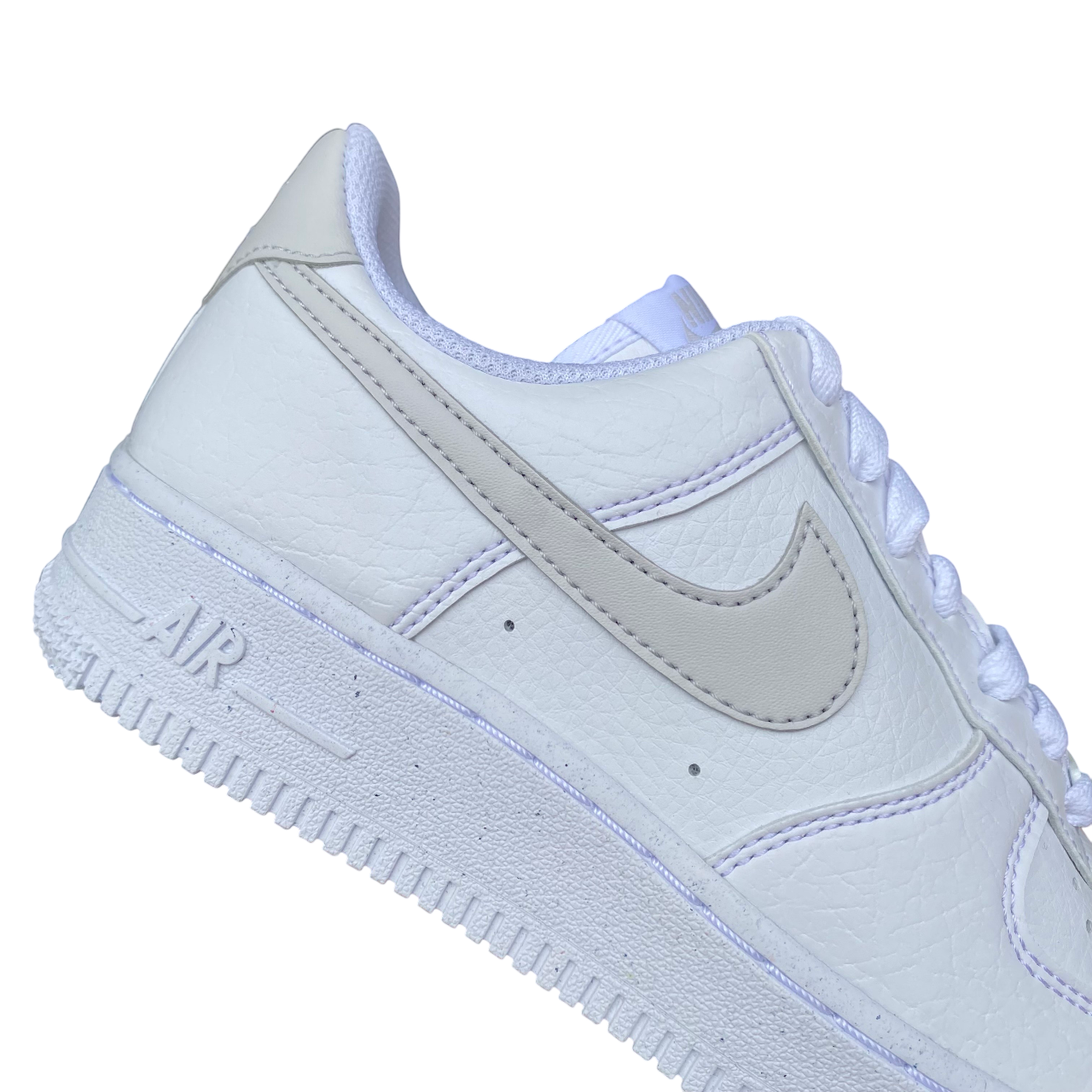 Primo piano del logo Nike sulle Air Force 1 '07 Next Nature bianco-grigio da donna