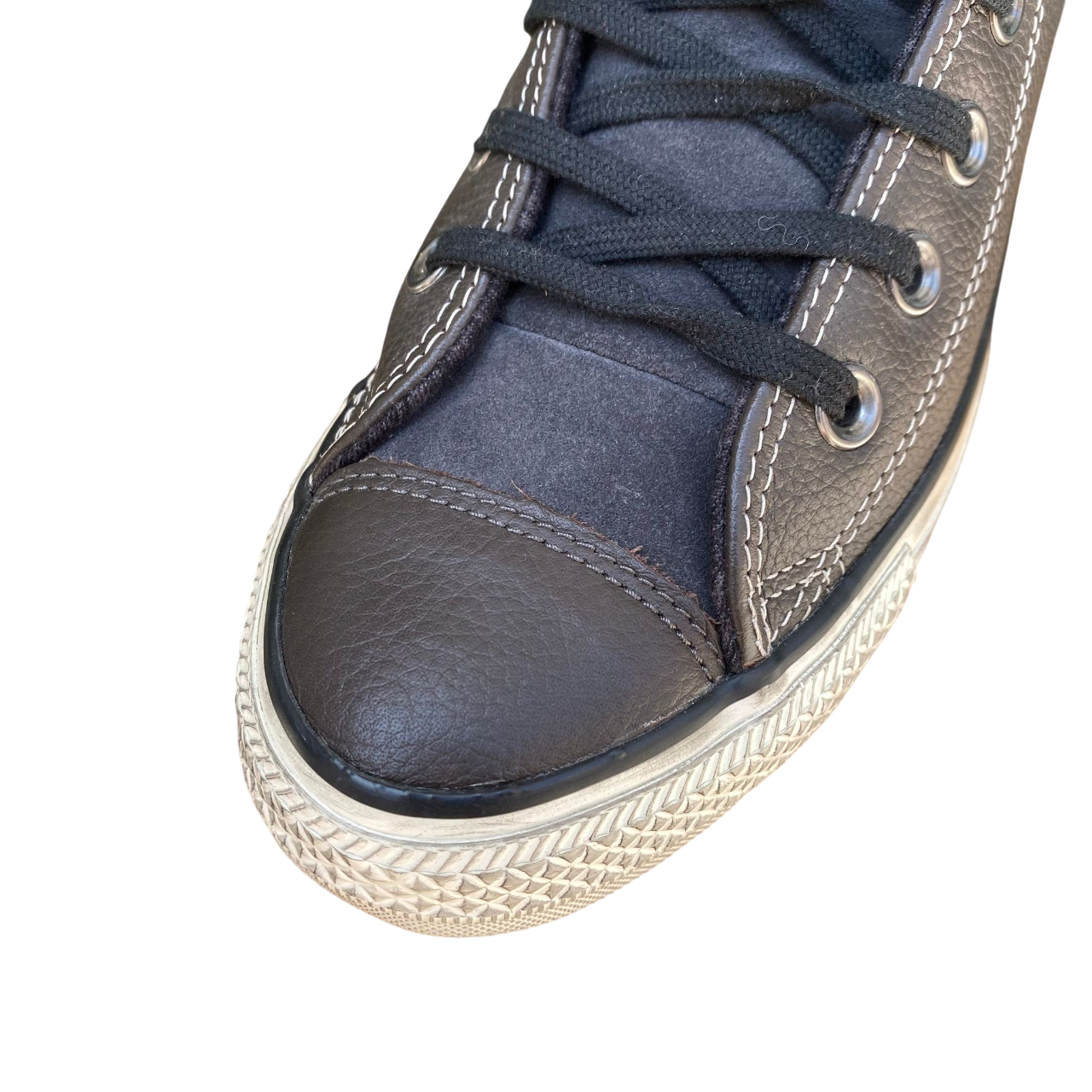 Dettaglio della pelle vintage e suola iconica delle Converse All Star Chuck Taylor per stile autentico e durata superiore - punta
