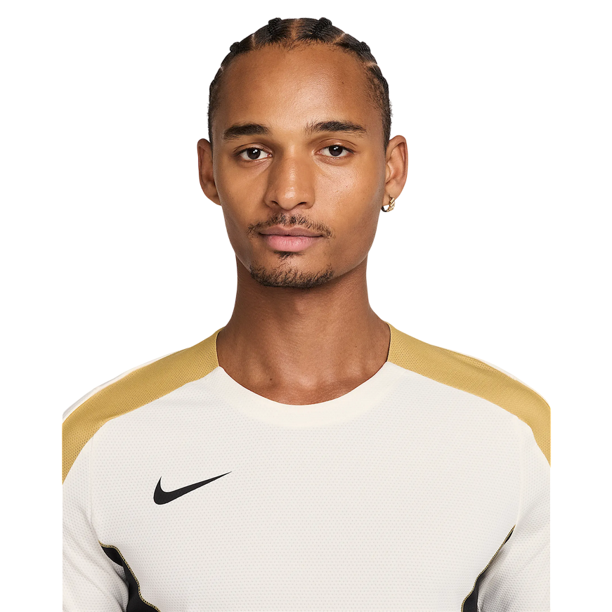 Maglia da calcio Nike Strike+ HJ4197-110 in colorazione Pale Ivory/Nero per uomo, con tecnologia Dri-FIT traspirante, mesh leggero e inserti laterali traforati per massima ventilazione durante allenamenti intensi