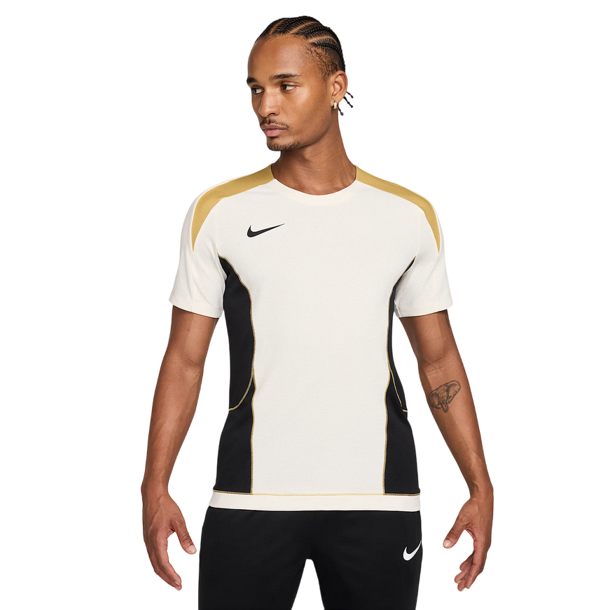 Maglia da calcio Nike Strike+ HJ4197-110 in colorazione Pale Ivory/Nero per uomo, con tecnologia Dri-FIT traspirante, mesh leggero e inserti laterali traforati per massima ventilazione durante allenamenti intensi