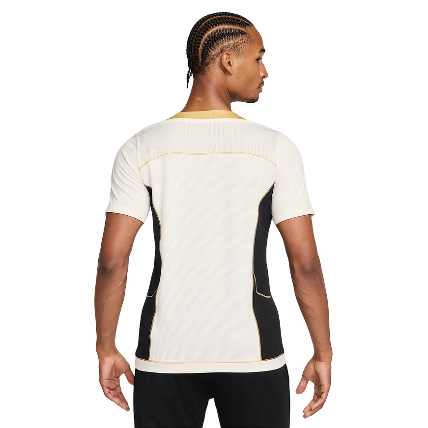 Maglia da calcio Nike Strike+ HJ4197-110 in colorazione Pale Ivory/Nero per uomo, con tecnologia Dri-FIT traspirante, mesh leggero e inserti laterali traforati per massima ventilazione durante allenamenti intensi